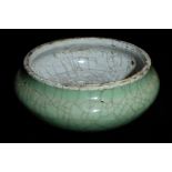 A CHINESE CELADON CRACKLE GLAZE POTTERY CENSOR Having a pale green exterior, grey interior and