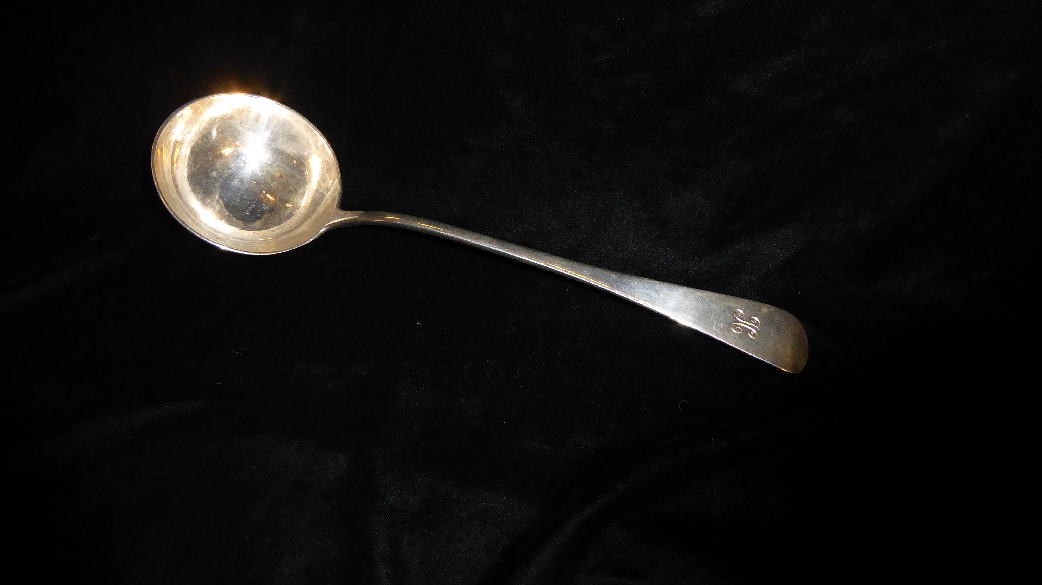 AN EARLY 20TH CENTURY SILVER SOUP LADLE Of plain form with engraved initial, hallmarked London,