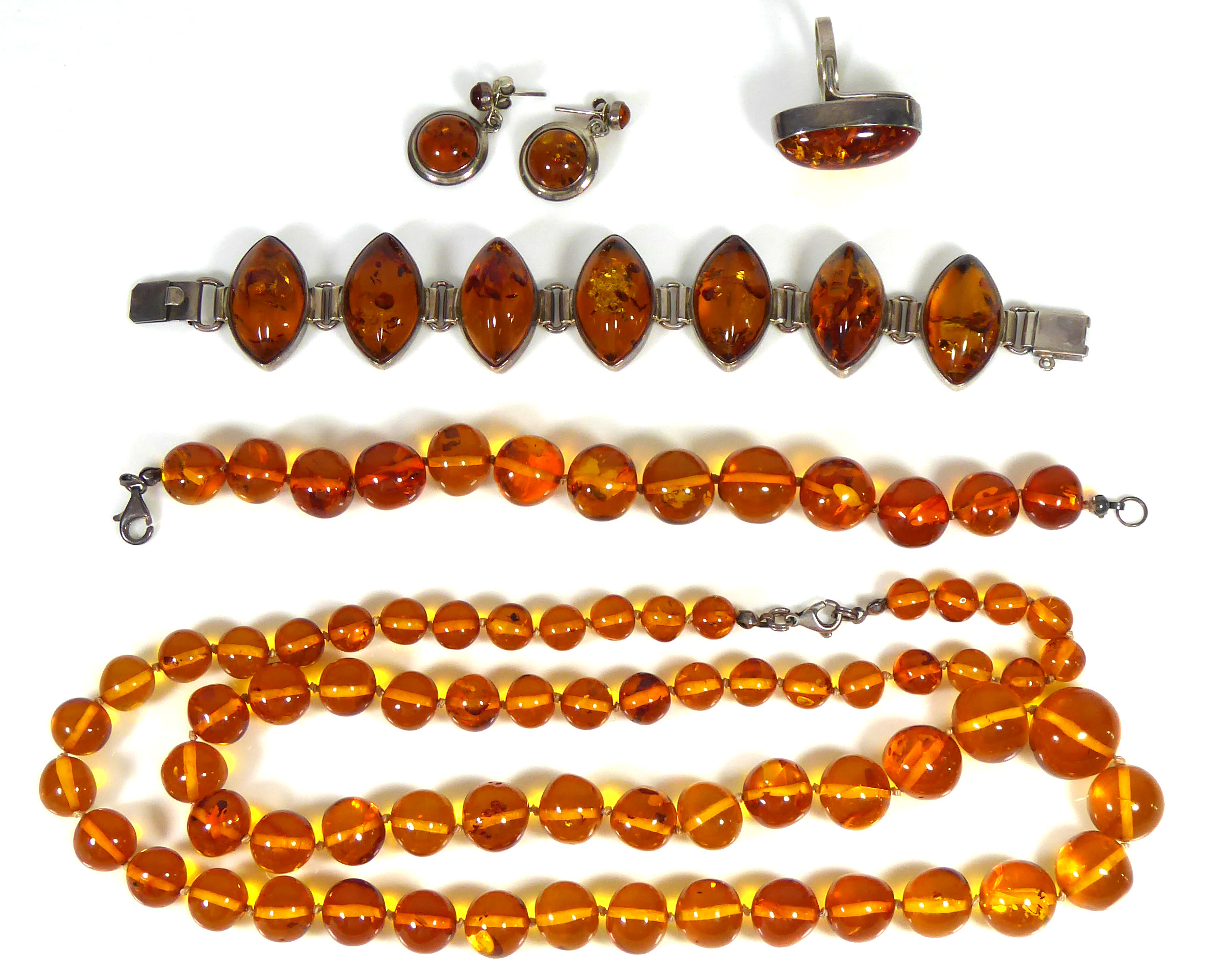 A COLLECTION OF VINTAGE SILVER AND AMBER JEWELLERY Comprising a bracelet set with lozenge form amber