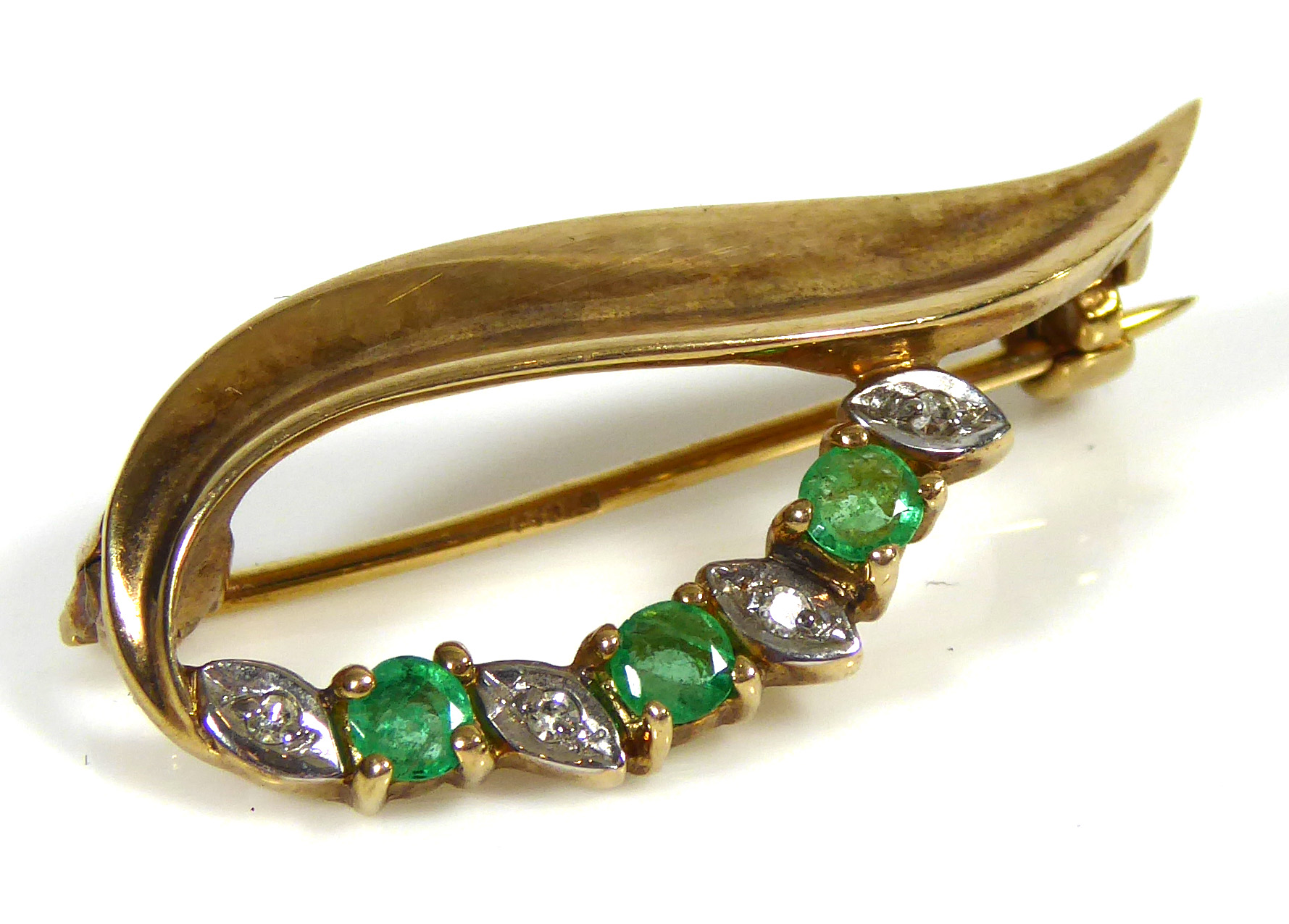 A VINTAGE 9CT GOLD, DIAMOND AND EMERALD BROOCH Set with three round cut emeralds interspersed with