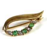 A VINTAGE 9CT GOLD, DIAMOND AND EMERALD BROOCH Set with three round cut emeralds interspersed with