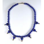 AN ART DECO SILVER GILT AND LAPIS LAZULI NECKLACE The spherical beads interspersed with triangular