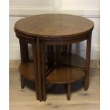 A 20TH CENTURY CIRCULAR WALNUT TOPPED NESTING/COFFEE TABLE Along with two 'X' frame stools.