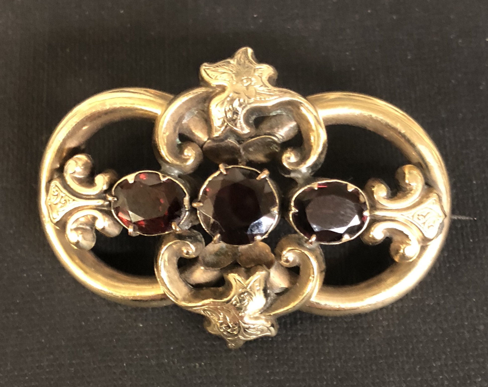 A VICTORIAN YELLOW METAL BROOCH SET WITH GARNETS.