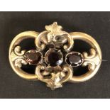 A VICTORIAN YELLOW METAL BROOCH SET WITH GARNETS.