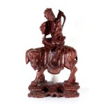 A CHINESE CARVED WOODEN FIGURAL GROUP An elder wearing long robes and carrying a quiver of arrows,