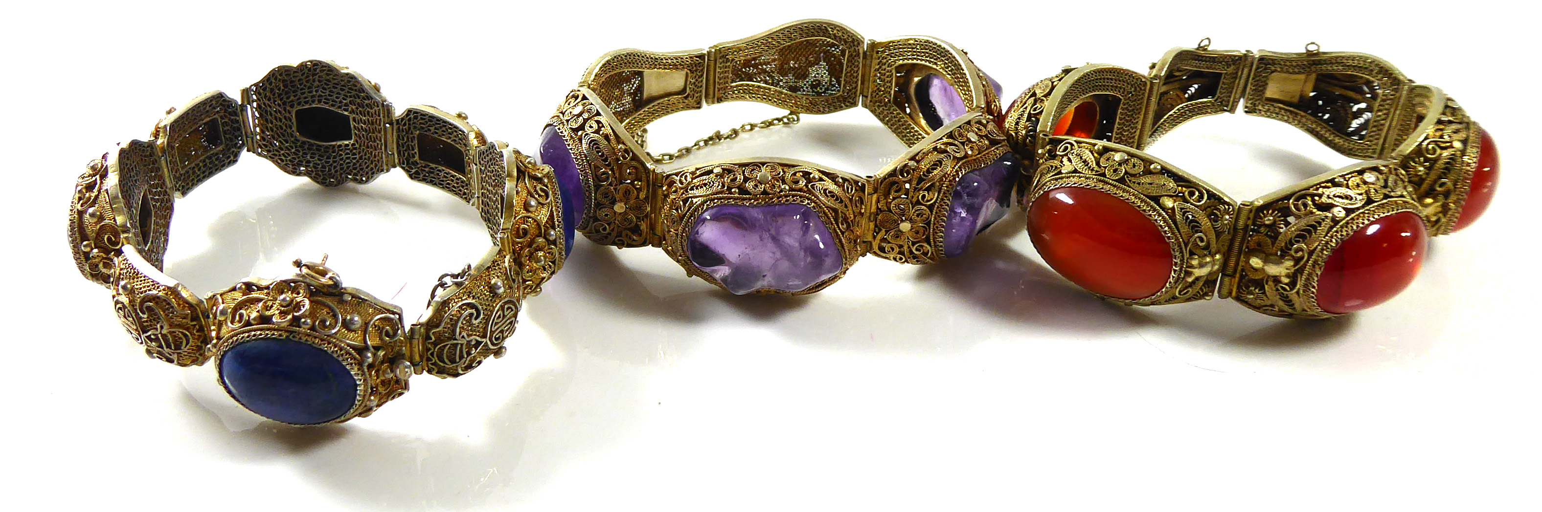 A COLLECTION OF THREE VINTAGE CHINESE SILVER GILT AND GEM SET BRACELETS Having amethyst, amber and