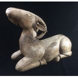 A 20TH CENTURY CARVED STATUE OF A RAM With incised features. (l 52cm x h 36cm x w 20cm)