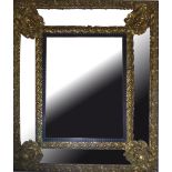 A 19TH CENTURY DUTCH CUSHION FRAME MIRROR With brass repoussé facial mask decoration and ebonised