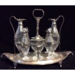 A GEORGIAN SILVER AND CUT GLASS EIGHT BOTTLE CRUET SET Classical oval form with scrolled handles and