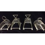 A COLLECTION OF FOUR EDWARDIAN SILVER TOAST RACKS Including a rack hallmarked Birmingham, 1906 and a