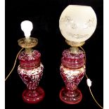 A PAIR OF LATE 19TH CENTURY CRANBERRY GLASS OIL LAMPS Converted to electricity, with hand