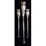A COLLECTION OF THREE EDWARDIAN NOVELTY SILVER OWL BUTTON HOOKS A pair hallmarked Birmingham,