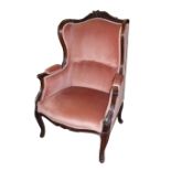 A 19TH CENTURY FRENCH WINGBACK ARMCHAIR With carved foliate decoration and peach upholstery,