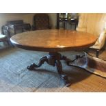 A VICTORIAN BURR WALNUT OVAL LOO TABLE On an octagonal column support, raised on carved scrolling