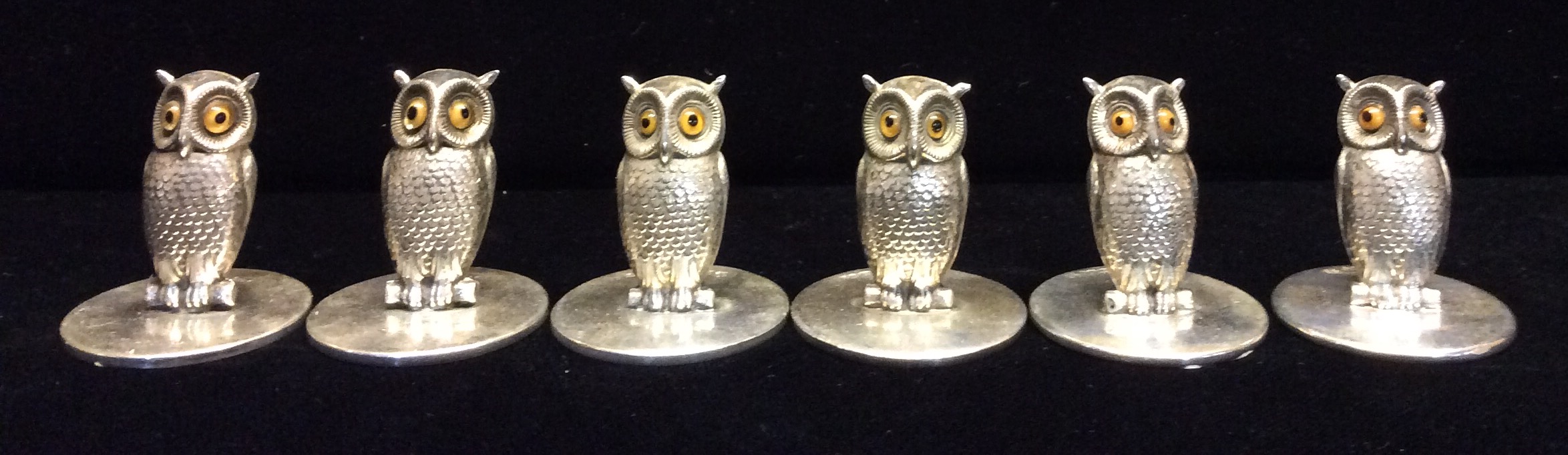 SAMPSON MORDAN, A SET OF FOUR EDWARDIAN NOVELTY SILVER OWL MENU HOLDERS With glass set eyes and