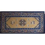 A 20TH CENTURY CHINESE CARPET With central floral medallion and stylized bats on a beige field,