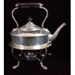 AN EDWARDIAN SILVER CIRCULAR SPIRIT KETTLE With ebonised wooden handle and finial, raised on four