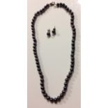 A VINTAGE BLACK PEARL AND SILVER NECKLACE AND EARRING SET The single strand of pearls with hook