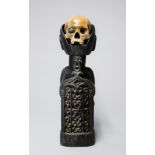 A LATE 19TH/EARLY 20TH CENTURY KORWAR TRIBE ANCESTOR HUMAN SKULL ON A CARVED WOODEN PEDESTAL. (h