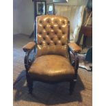 A VICTORIAN MAHOGANY FRAMED OPEN ARMCHAIR With tanned button back leather and scrolled arms,