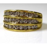 AN 18CT GOLD AND DIAMOND RING Three rows of round cut diamonds on a plain gold band (size O). (