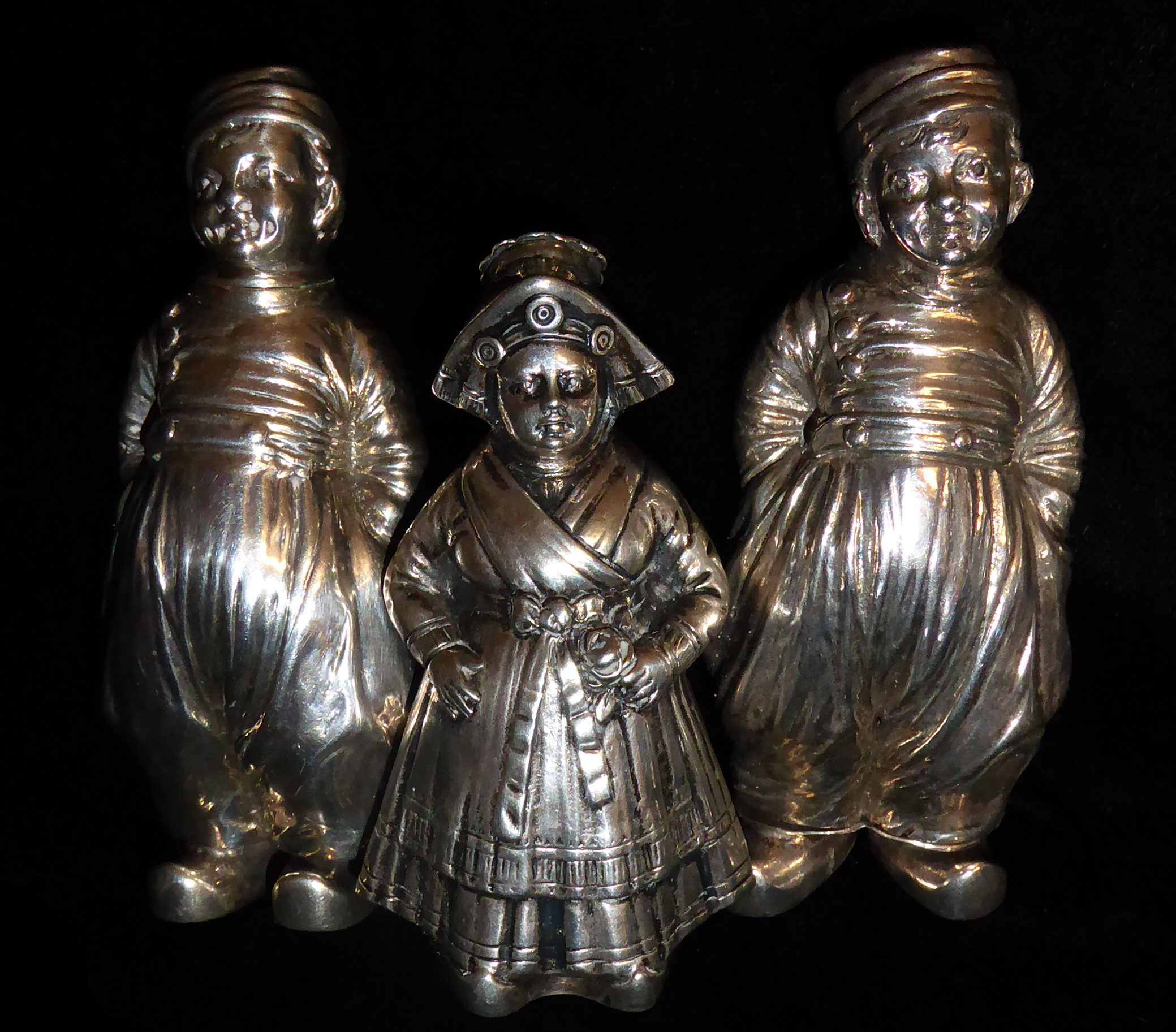 A COLLECTION OF THREE EARLY 20TH CENTURY DUTCH SILVER PEPPER POTS Two modelled as boys, marked 'BHM'