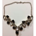 A CONTINENTAL WHITE METAL AND SMOKY QUARTZ NECKLACE The single line of faceted cut quartz