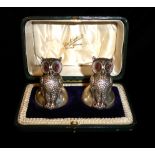 A CASED PAIR OF EDWARDIAN SILVER NOVELTY OWL MENU PLACE CARD HOLDERS Having amber glass eyes and