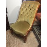 A VICTORIAN GOLDEN OAK NURSING CHAIR In green velvet button back upholstery.