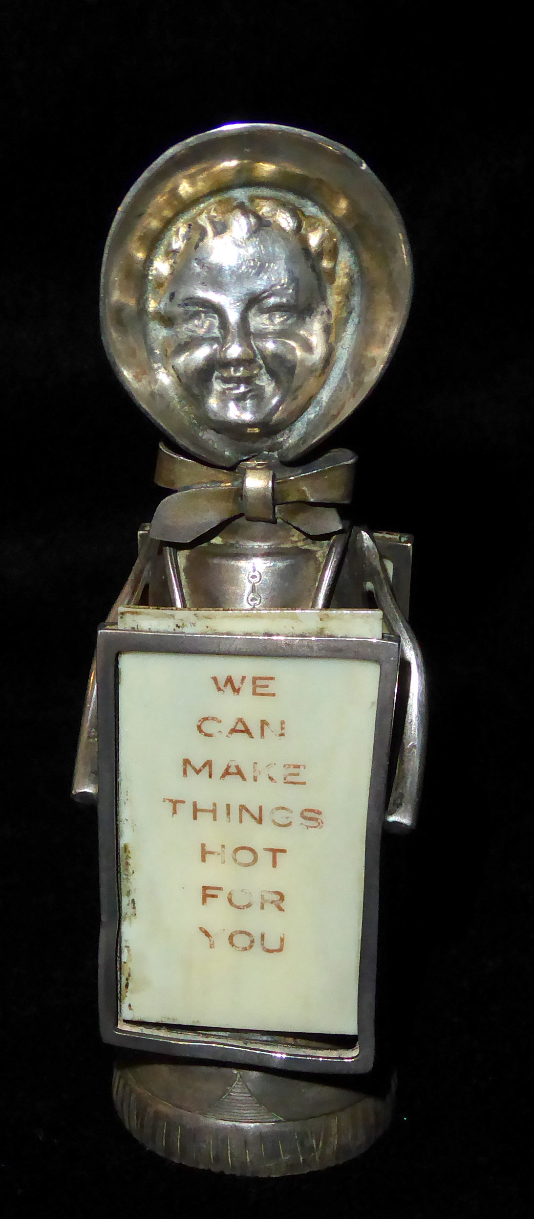 AN EDWARDIAN NOVELTY SILVER SUFFRAGETTE PEPPER POT Wearing a bonnet and holding two ivorine