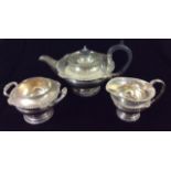 AN EARLY 20TH CENTURY THREE PIECE CIRCULAR SILVER TEA SET Comprising a teapot, sugar basin and cream