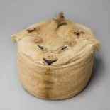 AN UNUSUAL EARLY 20TH CENTURY TAXIDERMY LION SKIN POUFFE. (h 38cm x w 48cm x d 48cm)