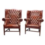 A PAIR OF GEORGIAN DESIGN RED LEATHER BUTTON BACK WING ARMCHAIRS Raised on square section legs