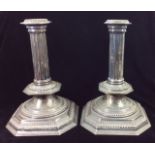 A PAIR OF VICTORIAN SILVER CANDLESTICKS Classical reeded column on an octagonal base, after a