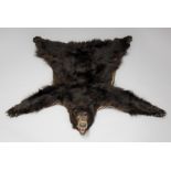 A 20TH CENTURY TAXIDERMY BLACK BEAR SKIN RUG WITH MOUNTED HEAD. (l 176cm x w 164cm)