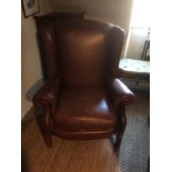 PARKER KNOLL, A GEORGE III DESIGN WINGBACK LEATHER ARMCHAIR Raised on square mahogany legs joined by