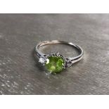 A 9CT WHITE GOLD AND PERIDOT DIAMOND RING, HAVING A PERIDOT WITH A DIAMOND EACH SIDE SIZE Q