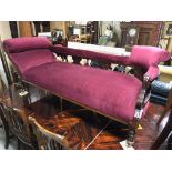 ANTIQUE CHAISE LOUNGE WITH BURGANDY VELVET UPHOLSTERY, CARVED DETAILS AND TURNED LEGS RAISED ON