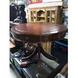 REPRODUCTION GEORGIAN STYLE MAHOGANY DRUM TABLE WITH RED LEATHER EMBOSSED TOP ON TURNED MAHOGANY