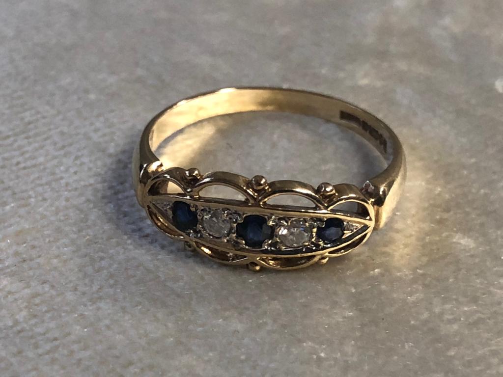 A 9CT GOLD SAPPHIRE AND DIAMOND RING HAVING A FILIGREE DESIGN WITH THREE SAPPHIRE AND TWO DIAMONDS