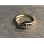 A 9CT GOLD AND DIAMOND RING HAVING THREE DIAMONDS SET IN A TWISTED SHANK SIZE N