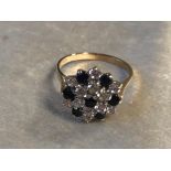 A 9CT GOLD DIAMOND AND SAPPHIRE CLUSTER RING, HAVING SET IN A DAISY DESIGN WITH DIAMOND AND