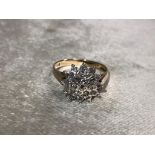 A 9CT GOLD AND DIAMOND CLUSTER RING HAVING A FLOWER SET IN DIAMONDS SIZE N