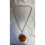 A LARGE SILVER AND AMBER PENDANT. AMBER CENTRE PIECE MEASURES 6.5CM X 5.15 CHAIN MEASURES 30CM