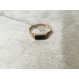 A 9CT GOLD RING HAVBING AN ONYX STONE WITH A KRISS CROSS DESIGN, EITHER SIDE. WEIGHT 1.51 RING