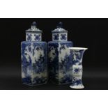 A pair of Chinese square section blue and white porcelain vases and covers, decorated with figures