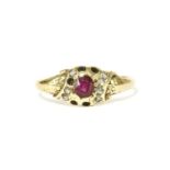 A gold oval cut ruby and rose cut diamond cluster ring, with engraved floral shoulders (five