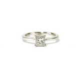 A white gold single stone Princess cut diamond ring, four claw set to knife edges, shoulders and