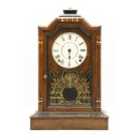 An early 20th century Seth Thomas walnut mantel clock, the circular dial with Roman numerals and